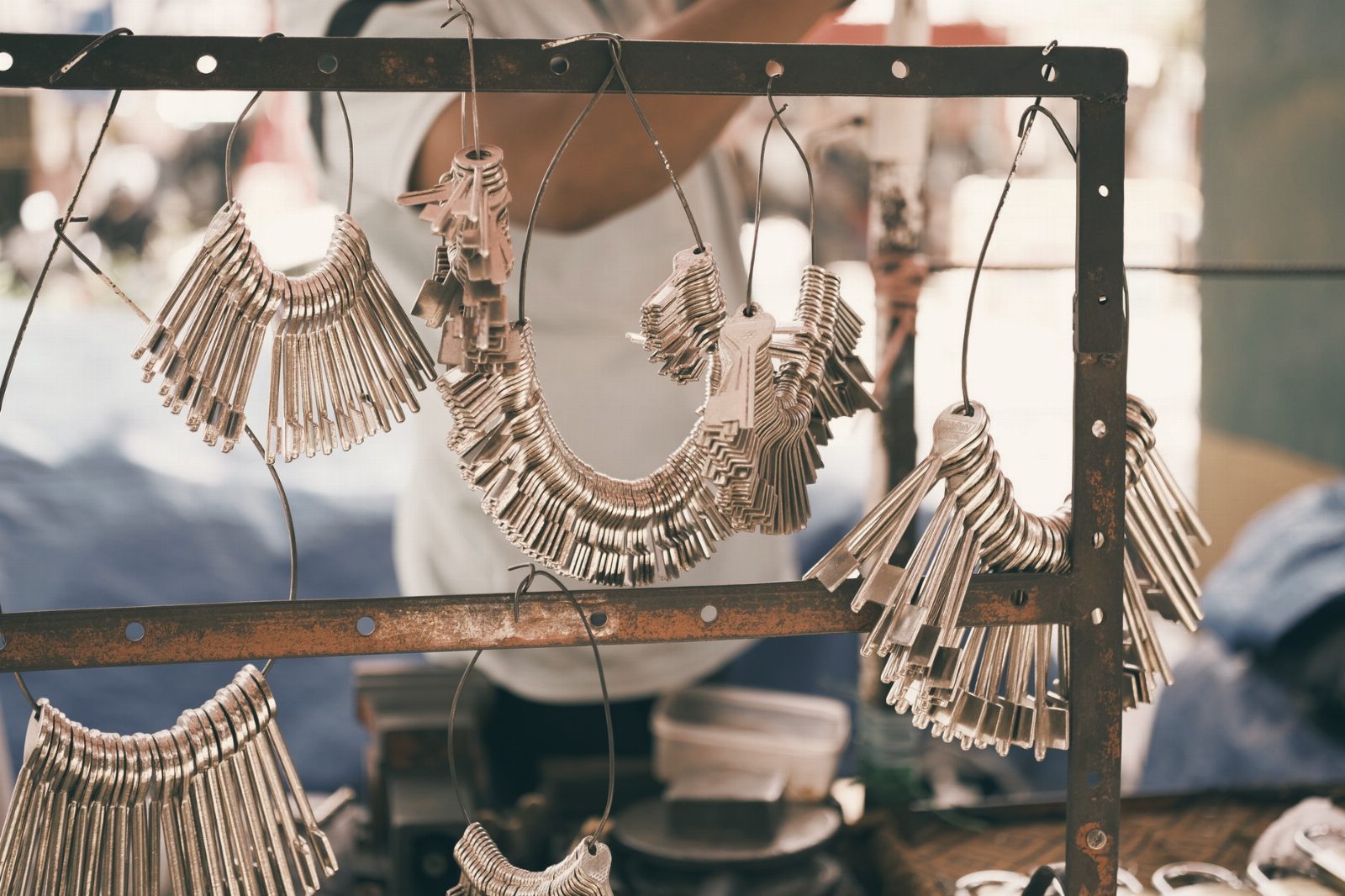 Close-up of numerous metal keys arranged on a display in a vibrant outdoor market.