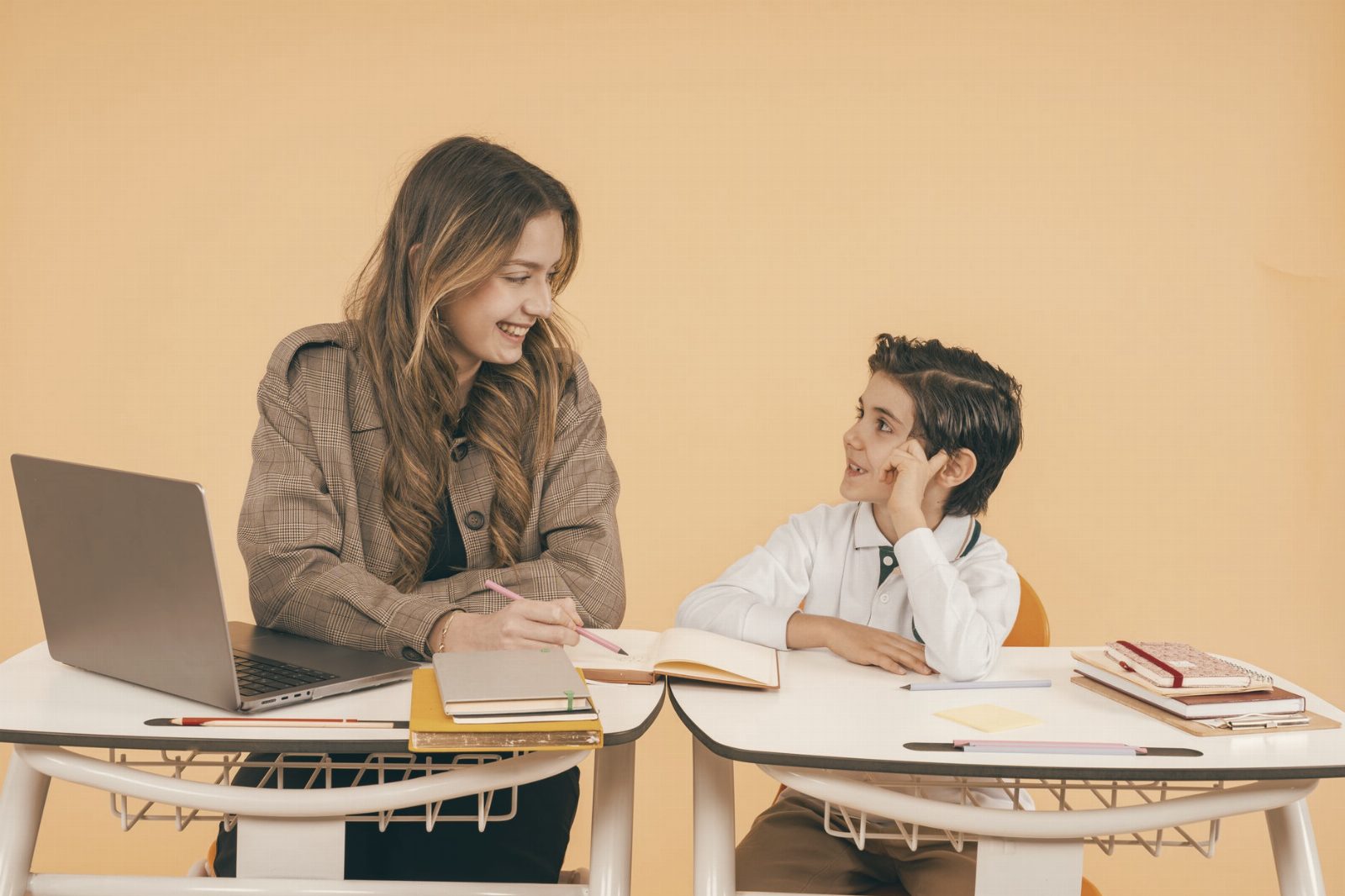 A teacher and student smile as they engage in a learning activity in a classroom.